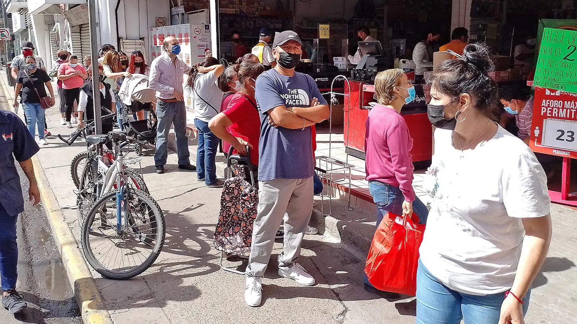 personas hacen fila frente a una papeleria